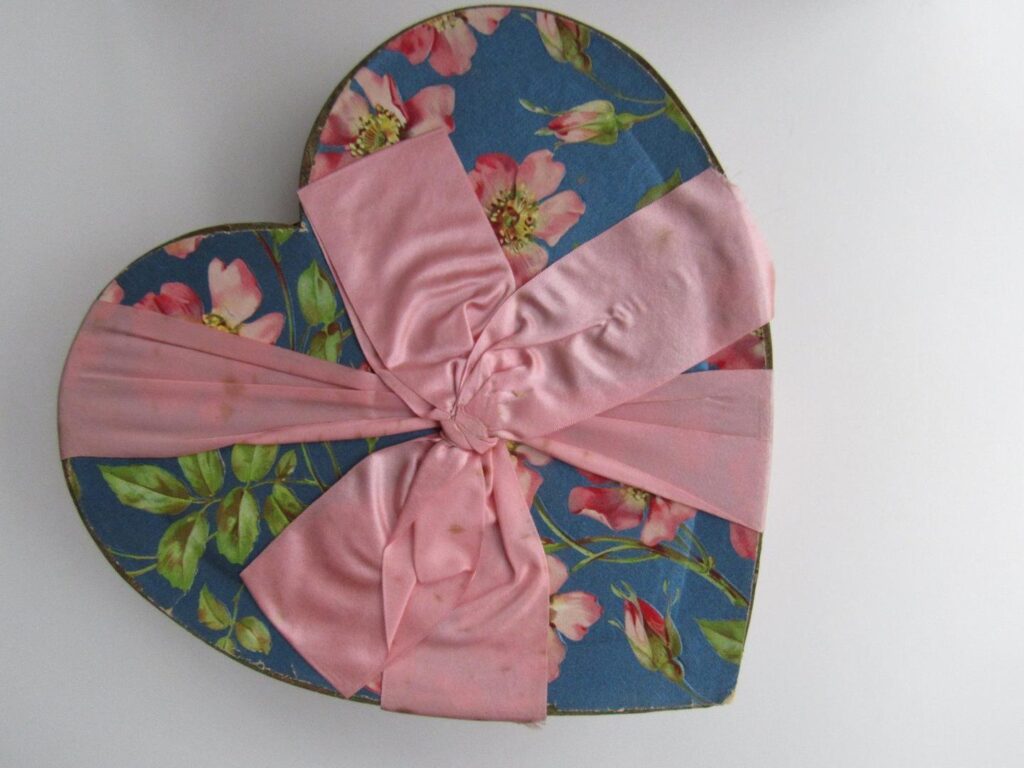 Antique Valentine candy heart cardboard box decorated with wild rose floral design on blue foil background